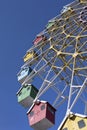 Colored cabins on a Ferris wheel against a blue sky