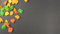 Colored candied fruits on a black background with copy space. Multi-colored pieces of dried fruits