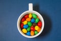 Colored candies in a white cup