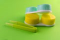 Colored cases for contact lenses for eyes on a green background. Royalty Free Stock Photo