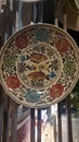 colored ceramic plates with fish and flower shapes, attached to a wooden fence.