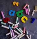 Colored chalks numbers and letters on blackboard
