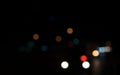 Colored circles bokeh of car lights at black dark night in city. Blurry abstract texture background. Royalty Free Stock Photo