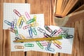 Colored clips for labeling tabs while studying at the mess of scattered on pieces of paper for notes. Old scribbled pencil thrown Royalty Free Stock Photo