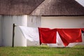 Colored cloth hanging on a clothesline against white town houses with thatched roofs