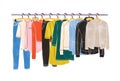 Colored clothes or apparel hanging on hangers on garment rack or rail isolated on white background. Clothing