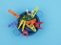 Colored clothespins in the bowl on a blue background Royalty Free Stock Photo