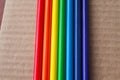 colored 7 color rainbow columns of pencils on a brown corrugated box surface background Royalty Free Stock Photo