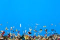 Colored confetti flying on blue background Royalty Free Stock Photo