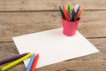 colored crayons and blank page on the wooden table