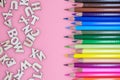 colored crayons and letters spread on pink background concept Royalty Free Stock Photo