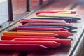 colored crayons, various colors of crayons on a wooden table with natural light and background window, diversity Royalty Free Stock Photo