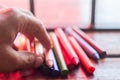 colored crayons, various colors of crayons on a wooden table with natural light and background window, diversity Royalty Free Stock Photo