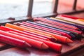 colored crayons, various colors of crayons on a wooden table with natural light and background window, diversity Royalty Free Stock Photo