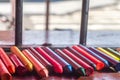 colored crayons, various colors of crayons on a wooden table with natural light and background window, diversity Royalty Free Stock Photo