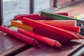 colored crayons, various colors of crayons on a wooden table with natural light and background window, diversity Royalty Free Stock Photo