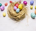 Colored decorative eggs for Easter, in the nest border place for text wooden rustic background close up