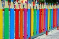 Colored decorative fence in the form of pencils on the street near the playground Royalty Free Stock Photo