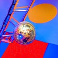 Colored disco ball on the background of a composition in the style of Suprematism