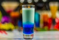 Colored drink in glass for shots, a combination of white with bl