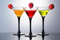 Coloured drinks in martini glasses with strawberries, cocktails with liqueurs Royalty Free Stock Photo