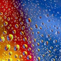 Colored drops of water on glass