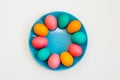 colored easter eggs round on a blue plate on a white background Royalty Free Stock Photo