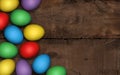 Colored easter eggs on dark wooden background. Rustic dark background. Colorful Easter eggs on a wooden table, decoration