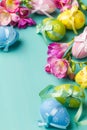 Colored Easter eggs and flowers on a turquoise table Royalty Free Stock Photo