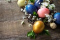 Colored Easter eggs in a nest with willow branches and spring flowers Royalty Free Stock Photo