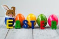 Colored Easter eggs with paper bunny and word easter made of magnet letters