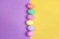 Colored Easter eggs on purple and yellow background. Royalty Free Stock Photo