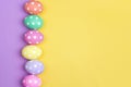 Colored Easter eggs on purple and yellow background. Royalty Free Stock Photo