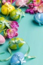Colored Easter eggs with ribbons and flowers on a turquoise table Royalty Free Stock Photo