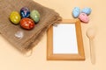 Colored Easter eggs on a sackcloth bag and a photo frame.