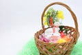 Colored Easter eggs and white lamb in a wicker basket Royalty Free Stock Photo