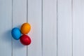 Colored Easter eggs on white wooden boards top view. red, blue, orange, holiday background Royalty Free Stock Photo