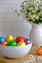 Colored Easter eggs with wild chamomy on old wood table on brick wall background Royalty Free Stock Photo
