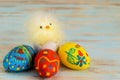 Easter eggs on wooden background next to basket with baby chicken Royalty Free Stock Photo