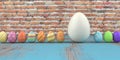 Colored easter eggs on the wooden table and brick wall in the background Royalty Free Stock Photo