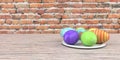 Colored easter eggs on the wooden table and brick wall in the background. Royalty Free Stock Photo