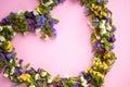 Colored flowers on pink background composition, heart shape
