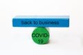 Colored fragments in fragile balance to underline the choice with the words: back to business COVID-19