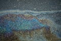A colored gasoline slick on a wet asphalt road highlighting the risks associated with pollution Royalty Free Stock Photo