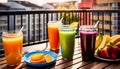 Colored glasses, jars of fruit juice and plates with healthy snacks located on the balcony, healthy eating concept,