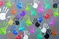 Colored hand palms on a gray wall. Children's handprints background. Charity, joy, party, holiday concept.