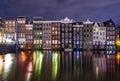 Colored homes on the water in Amsterdam at night Royalty Free Stock Photo