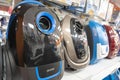 colored household vacuum cleaners on a supermarket shelf, sale of vacuum cleaners in a home appliance store