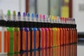 Colored inks in plastic containers formed in a row and background bokeh Royalty Free Stock Photo