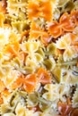 Colored italian cooked pasta farfalle tricolore abstract background.